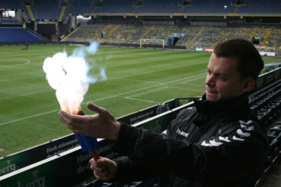 Der Fanbeauftragte von Brøndby IF, Lasse Bauer, zündet im Stadion eine Testversion der ungefährlichen Pyrotechnik.