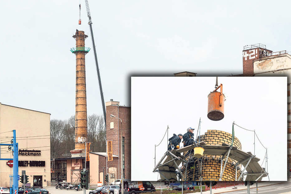 Auf dem Poelzig-Areal in der Ulmenstraße sanieren Mitarbeiter der Firma S + F
Bau den Klinkerschornstein.
Abgebrochene Ziegel sammeln sie in einer Tonne, die am Kran zu Boden schwebt.
(kl.F.).