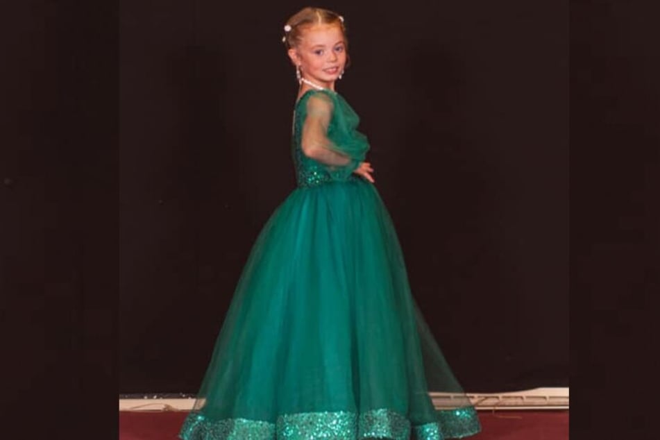 Lola (7) in einem flaschengrünen bodenlangen Ballkleid.