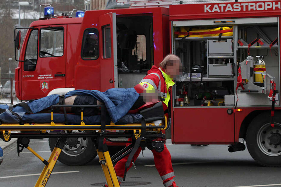 Sanitäter transportieren den schwerverletzten 23-Jährigen ab. Der Mann überlebte in der Brandwohnung.