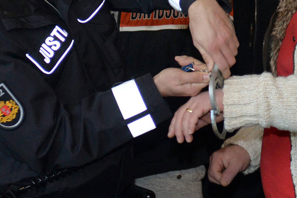 Dem Angeklagten werden vor Prozessbeginn die Handschellen abgenommen. (Archivbild)