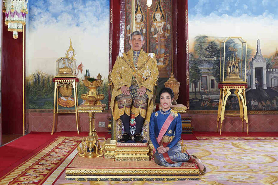 König Maha Vajiralongkorn von Thailand sitz auf seinem Thron, während neben ihm Sineenat Wongvajirapakdi kniet. (Archivbild)