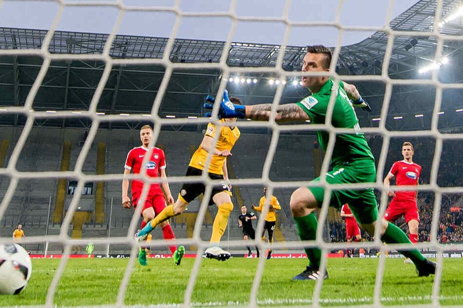 Heidenheims Schlussmann Kevin Müller schaut dem Ball hinterher, während Stefan Kutschke nach dem Siegtreffer jubelnd abdreht.