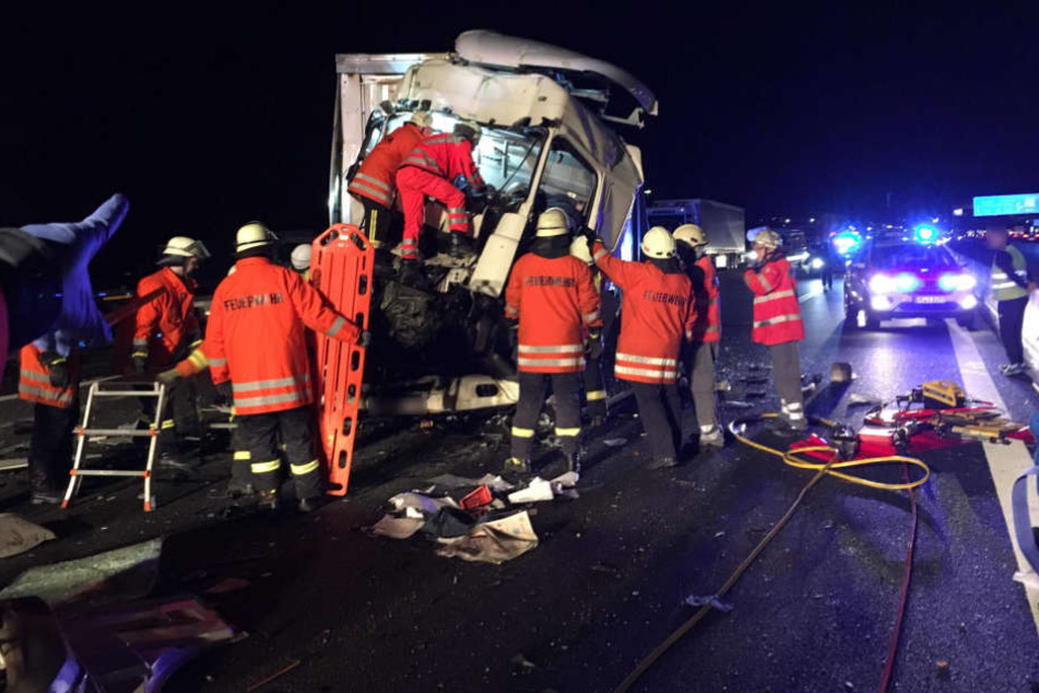 Einsatzkräfte bergen den im Lkw eingeklemmten Fahrer.