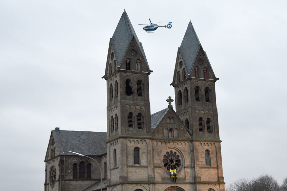 Ein Polizeihubschrauber kreist um die Kirche, die die Aktivisten besetzt haben.