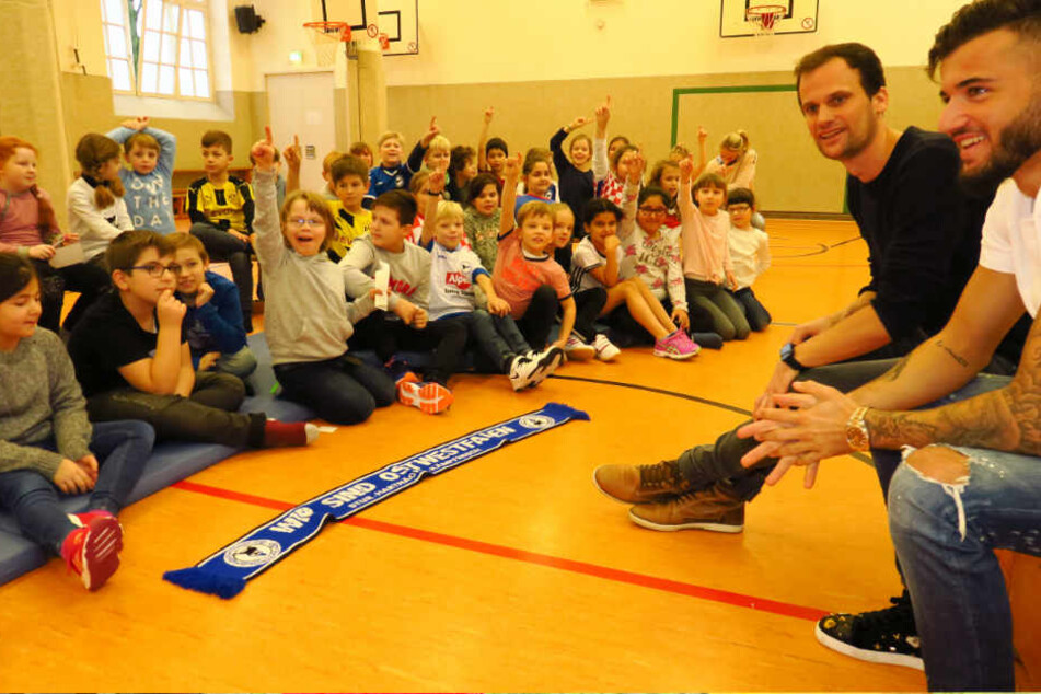 Arminias Keanu Staude (r.) und Sportlehrer Tobias Limberg beantworten die Fragen der Kinder.