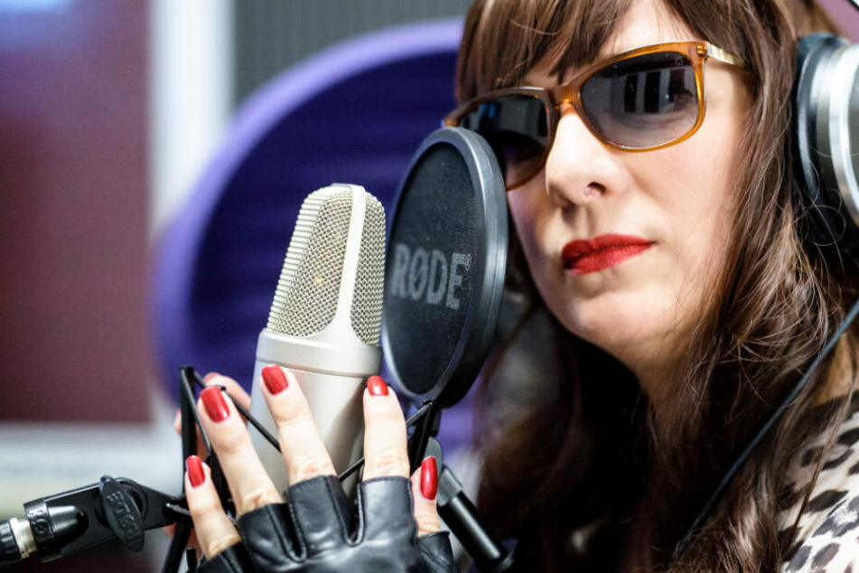 Dea Levina, Mental Domina, haucht in einem Tonstudio in ein Mikrophon.