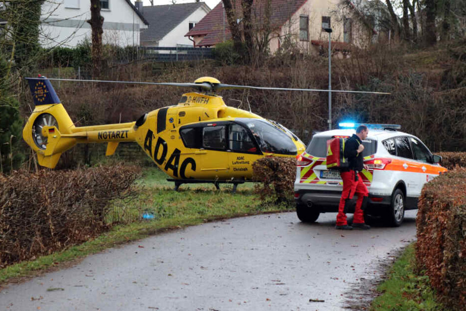 Ein Hubschrauber landet neben einem Notartztwagen.