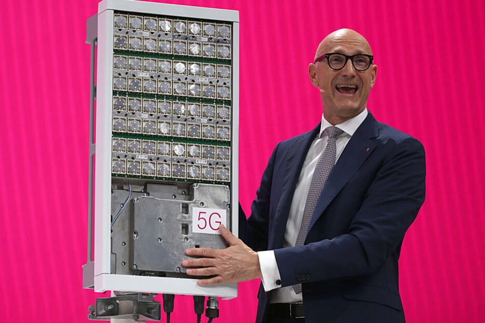 Timotheus Höttges, Vorstandsvorsitzender der Deutschen Telekom, spricht neben einer 5G Antenne zu den Aktionären.