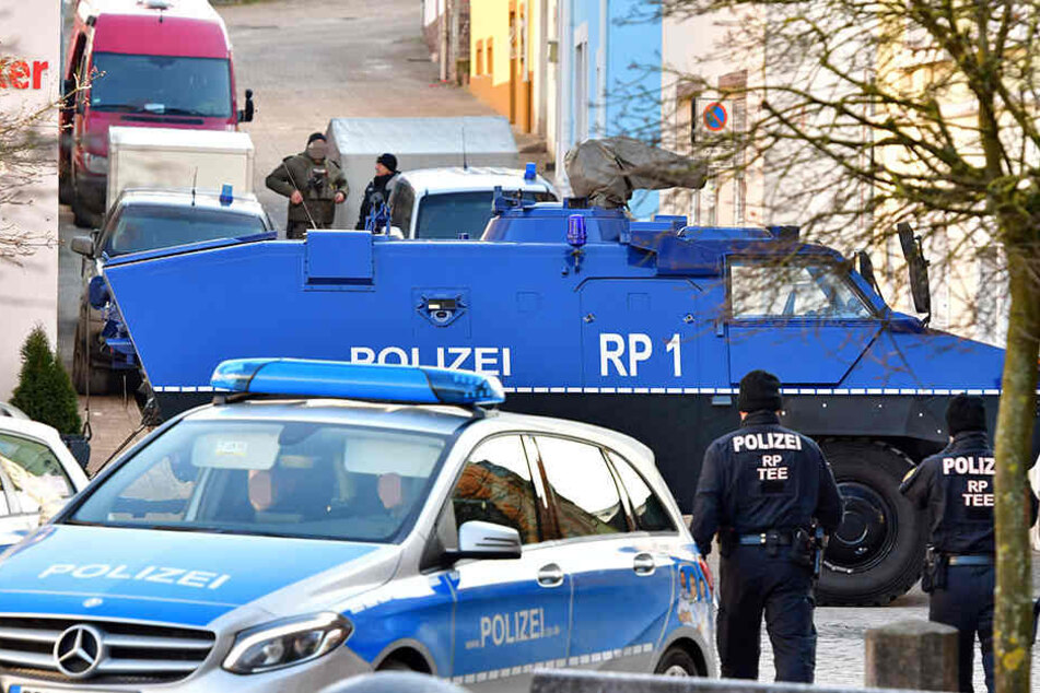 Ein Panzerwagen sichert die Zufahrt in eine Straße, in der in einem Privathaus bei einer Durchsuchung etwa 100 Kilogramm Sprengstoff gefunden wurden.