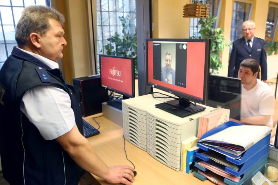 Ein Beamter schaut über das Gespräch mit drüber, kann aber nicht zuhören.