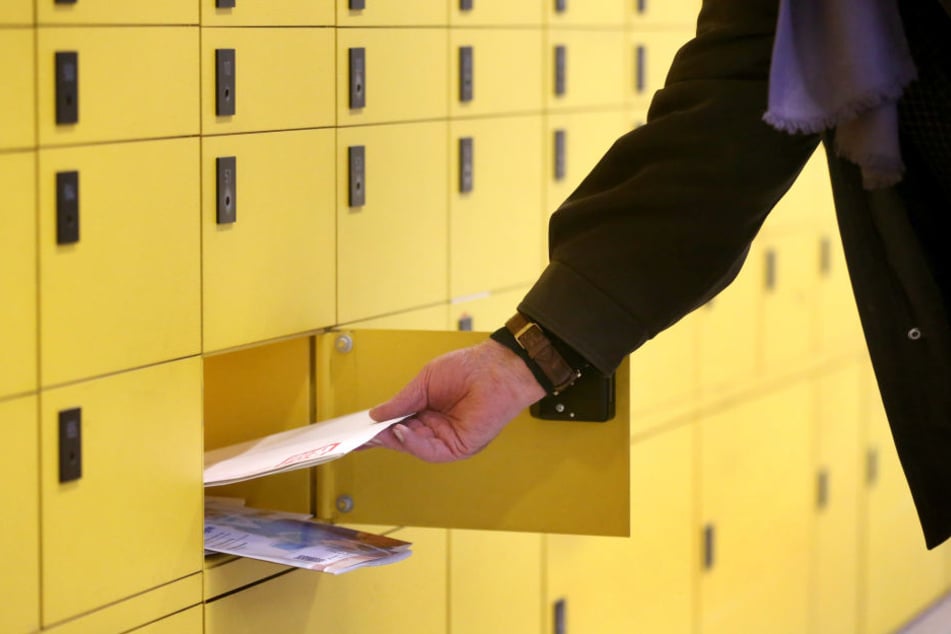 Ein Kunde leert sein Postfach bei der Post.