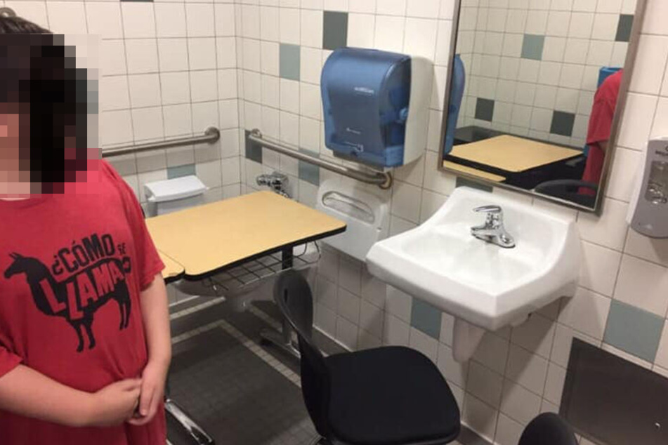 Lucas Goodwin steht beschämt vor seinem Schreibtisch in der Schultoilette.