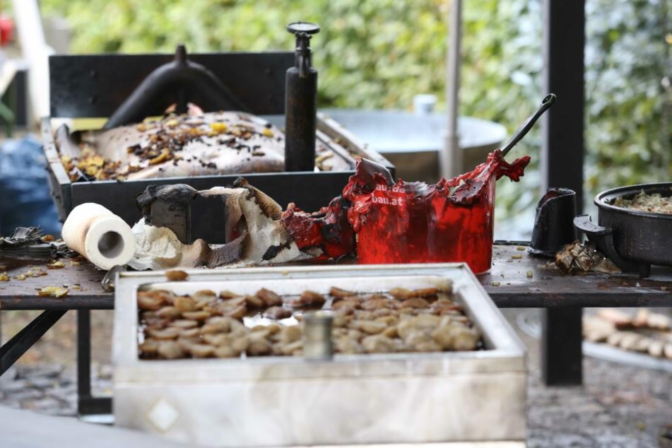 Verbrannte Grill-Utensilien sind auf einem Tisch auf dem Gelände des Festes zu sehen.