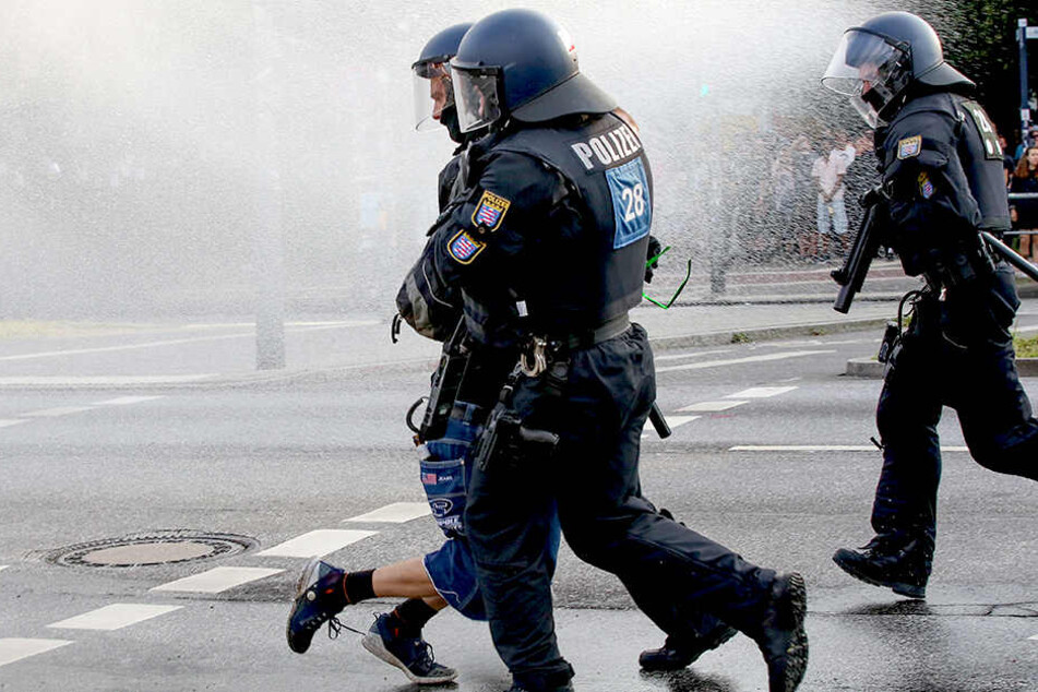 Polizisten nehmen am Pferdemarkt in Hamburg eine Person während eines Wasserwerfereinsatzes in Gewahrsam.