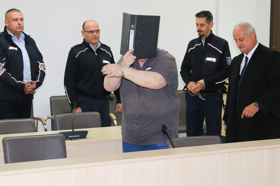 Der Angeklagte versteckte sich zu Beginn des Prozess hinter einem Aktenordner.
