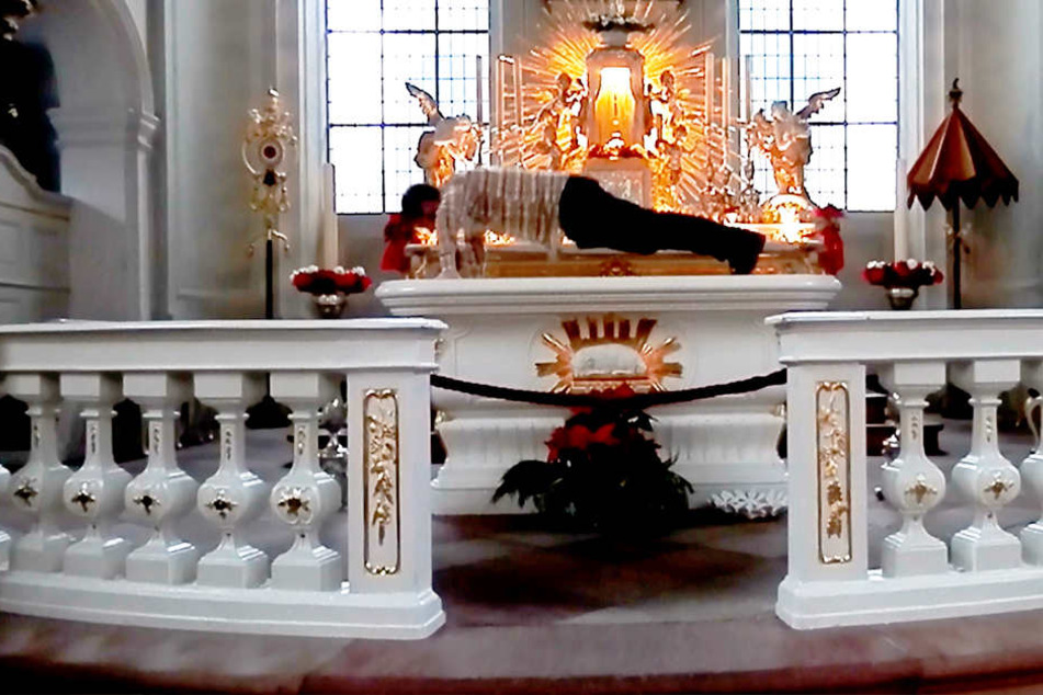 Der Künstler Alexander Karle macht für sein Kunstprojekt Liegestütze auf dem Altar der katholischen Kirchengemeinde St. Johann in Saarbrücken.