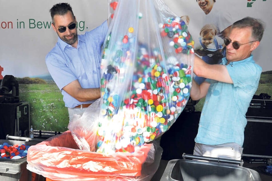 Gerold Münster (l.) und Manfred Wipper schütten tausende Plasteverschlüsse in
eine Tonne.