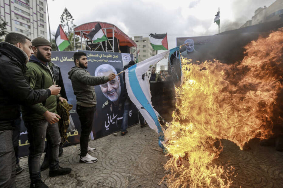 Palästinenser verbrennen eine israelische Flagge im Zuge einer Trauerzeremonie in Gedenken an Qassem Soleimani.