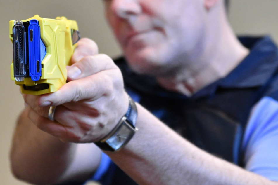 Ein Polizeibeamter zeigt bei einem Pressetermin die Handhabung einer Elektroimpulswaffe (Archivbild).