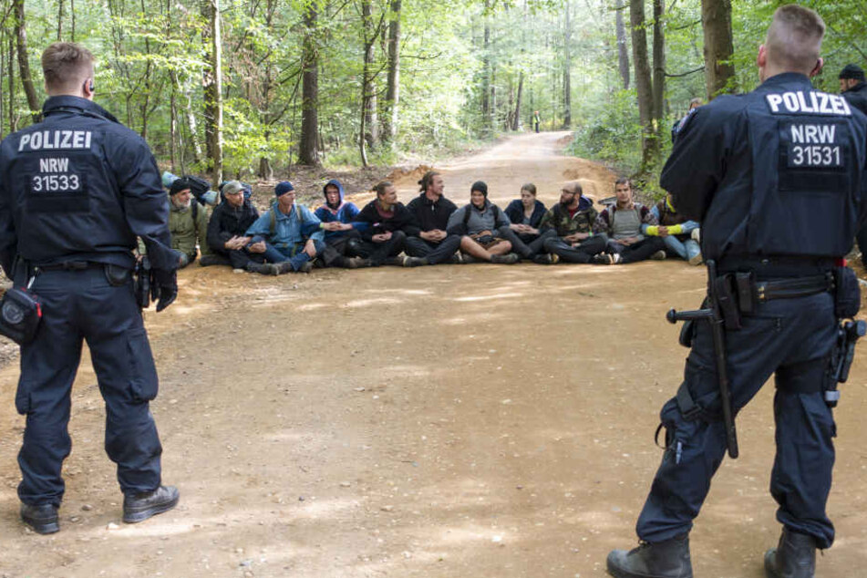 Polizisten beobachten eine Sitzblockade im Hambacher Forst.