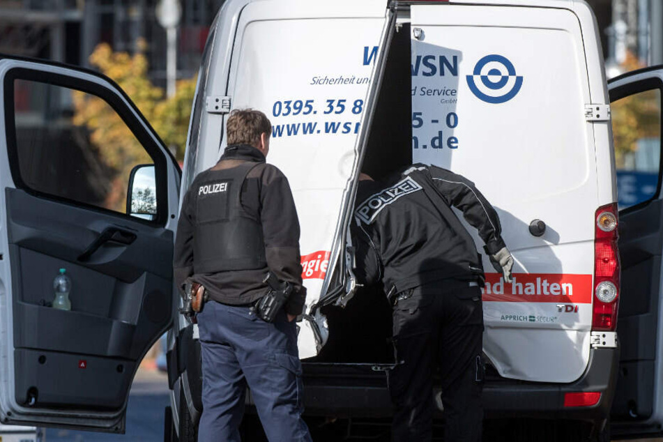 Polizeibeamte stehen an einem Geldtransporter mit aufgebrochenen Türen. (Archivbild)