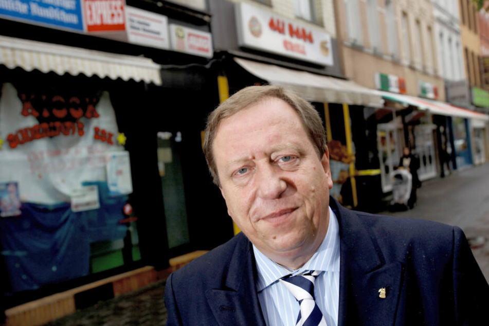 Josef Wirges, SPD-Bezirksbürgermeister von Köln-Ehrenfeld, steht vor Geschäften auf der Venloer Straße.