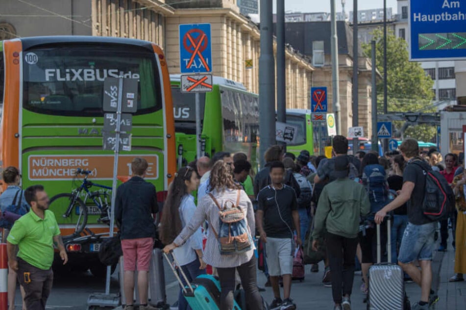 Dicht gedrängt stehen die Passagiere vor den rangierenden Bussen.