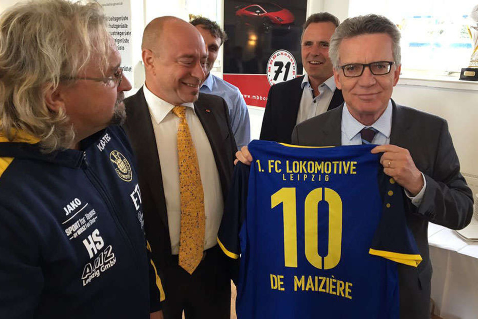 Stolz hält der Bundesinnenminister sein blau-gelbes Trikot in die Kamera.