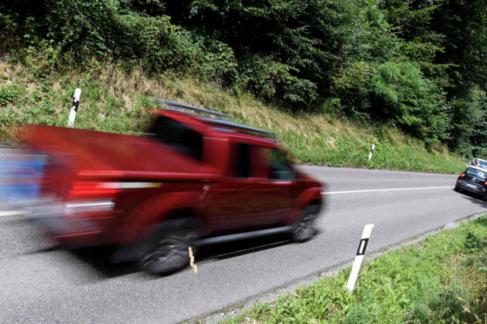 Ein Auto fährt auf einer Landstraße.