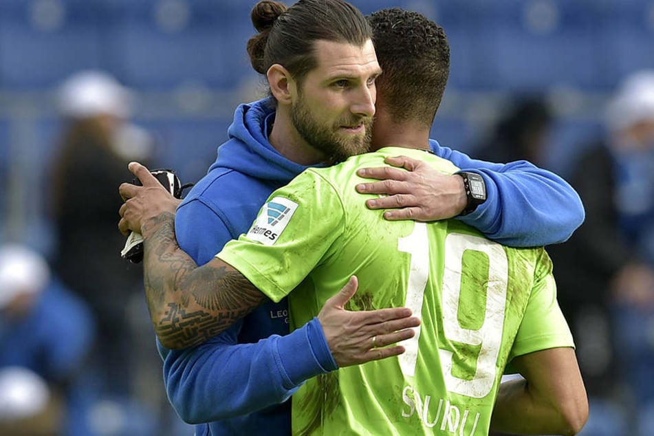 Robin Lenk (l.) nimmt Cebio Soukou
nach der Partie an seine Brust. Aus 0:2 ein 2:2 gemacht - Interimscoach Lenk war damit zufrieden.
