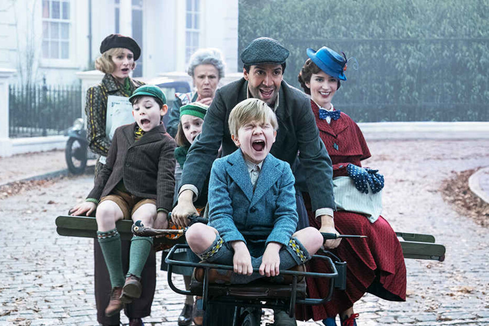 Ein Großteil der Familie Banks macht sich mit Jack (Zweiter von links, Lin-Manuel Miranda) und Mary Poppins (r., Emily Blunt) auf den Weg, um das Haus zu retten.