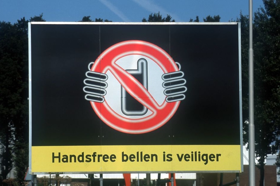 In Holland warnen Schilder vor der Handynutzung am Steuer.