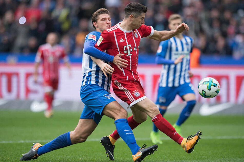 Berlins Niklas Stark (l) kämpft um den Ball gegen Bayerns Robert Lewandowski.