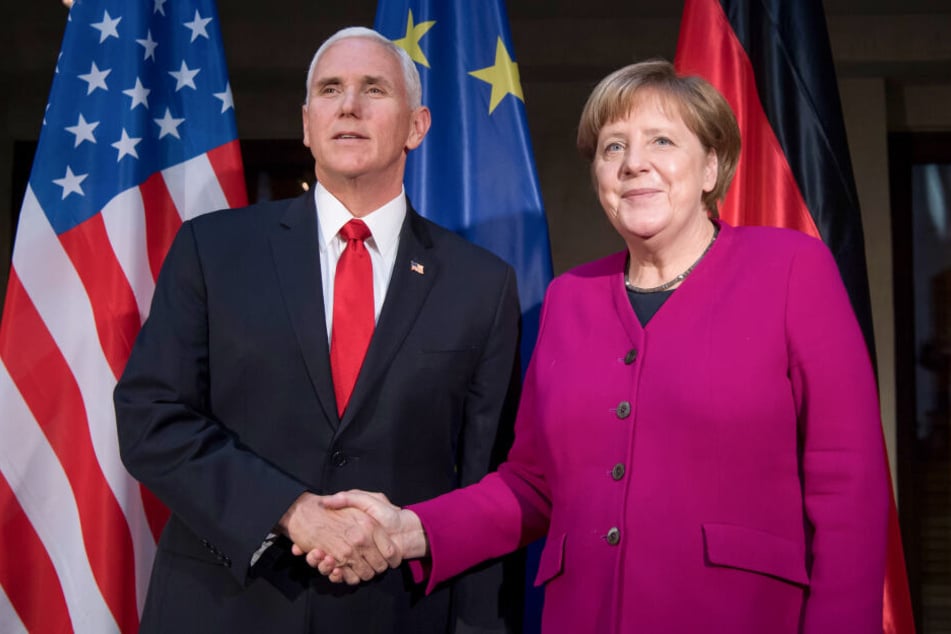 Bundeskanzlerin Angela Merkel (CDU) und Mike Pence, Vizepräsident der USA, begrüßen sich am zweiten Tag der Münchner Sicherheitskonferenz zu Beginn eines Gesprächs.