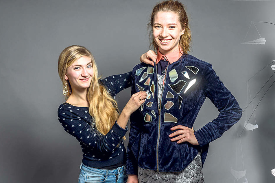 Alrike
Gutsche
(22, l.)
putzt die
Spiegelstücke
auf der
Jacke
ihres
Models
Lisa (21).
Für ihre
Kollektion
hat
sie zehn
Spiegel
zerscherbelt.