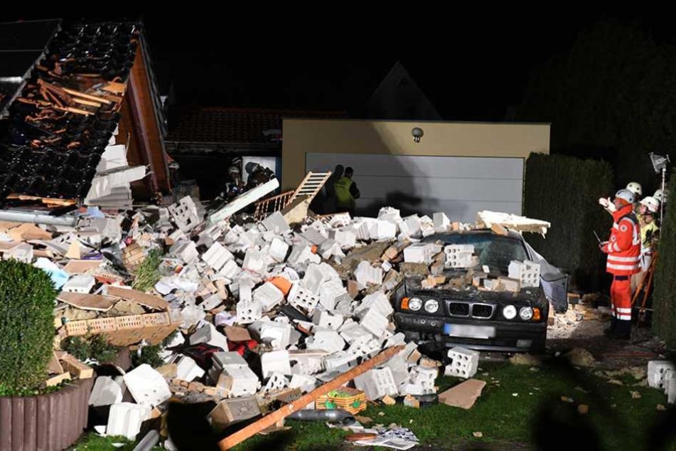 Rettungskräfte untersuchen die Trümmer des eingestürzten Hauses.
