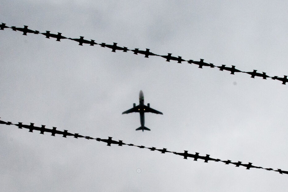 Ein Flugzeug ist hinter Stacheldraht zu sehen (Symbolbild).