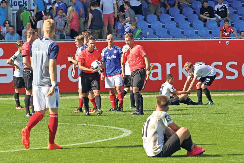 Nach dem Abpfiff hocken die Zwickauer Spieler enttäuscht auf dem Rasen.