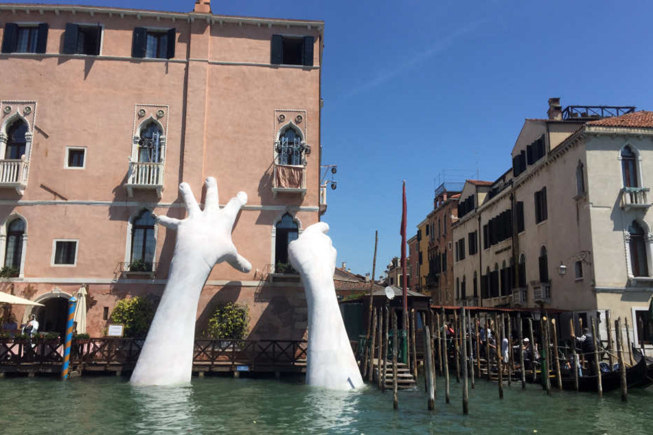 Ein Künstler lässt in Venedig diese riesigen Hände aus einem Kanal schauen.
