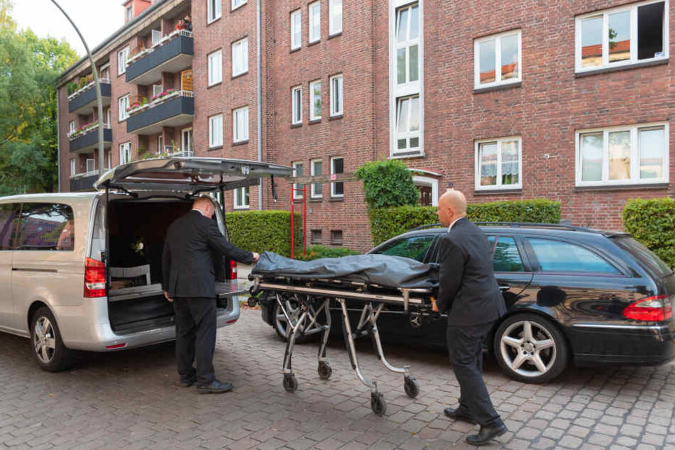 Bestatter beim Abtransport der Leiche.