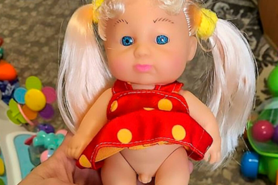 Die Puppe versteckt unter ihrem gepunkteten Kleid einen kleinen Penis.