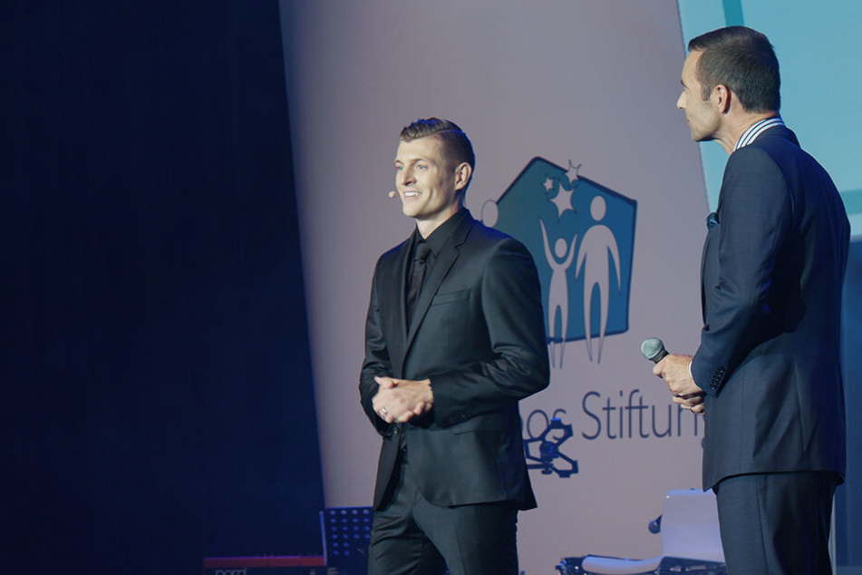 Toni Kroos (l.) hält bei einer Gala seiner Stiftung eine Rede.