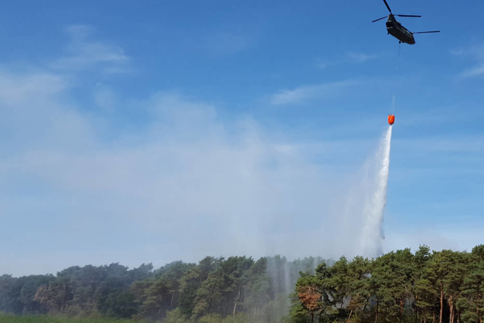 Ein Hubschrauber der niederländischen Armee unterstützt die Löscharbeiten im niederrheinischen Straelen.