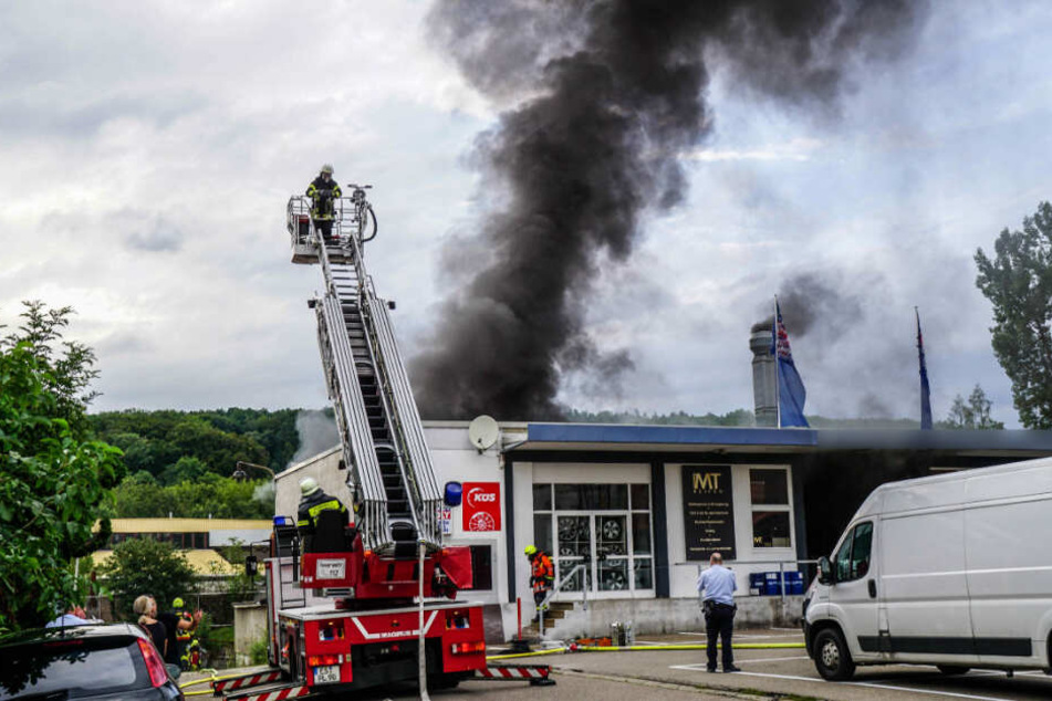 Feuerwehrleute löschen Brand mit Drehleiter.