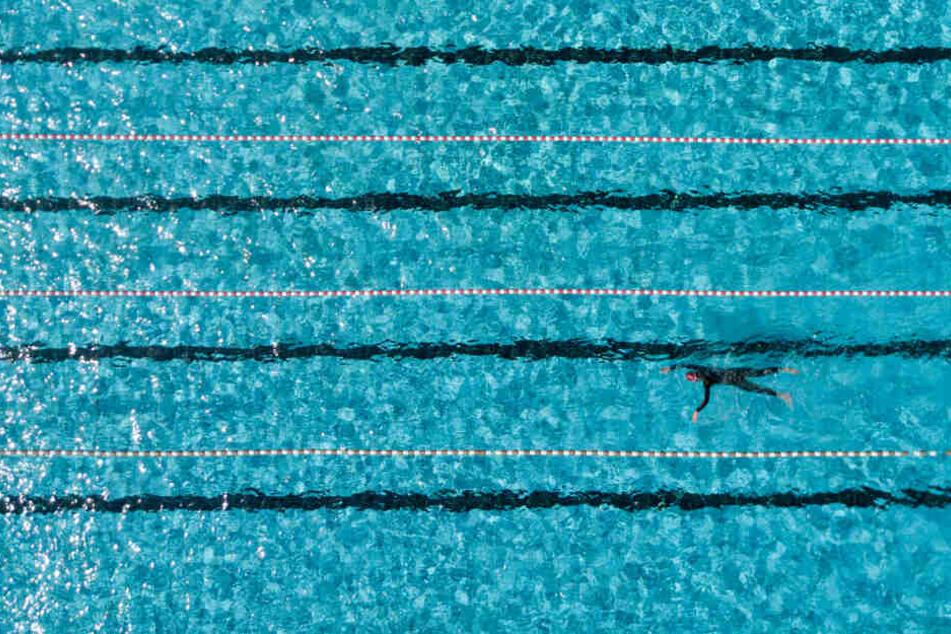 Ein Badegast schwimmt in einem Hamburger Freibad im 50-Meter-Becken.