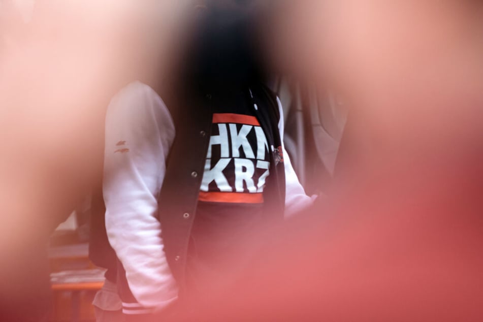 Ein Mann trägt am auf dem Gelände eines Rechtsrock-Konzertes in ein T-Shirt mit der kryptischen Aufschrift "HKNKRZ", das für das Hakenkreuz-Symbol stehen soll. (Archivbild)