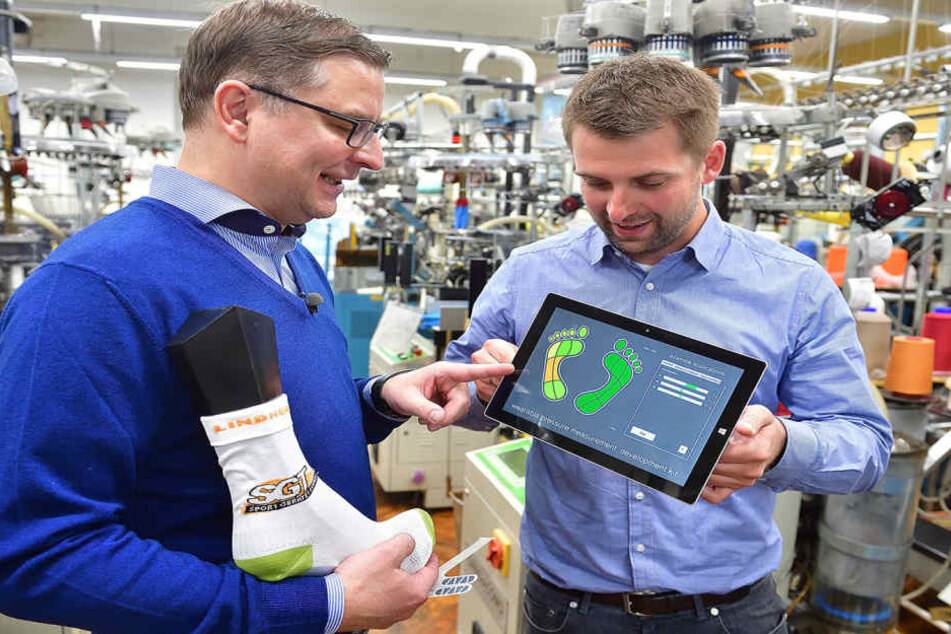 Markus Hill (r.), Wissenschaftlicher Mitarbeiter, und Textilhersteller Thomas
Lindner prüfen die Sensoren der smarten Socke.
