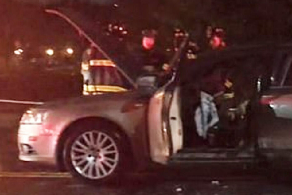 Die Beamten stehen vor dem Audi A6, in dem es gebrannt hat.