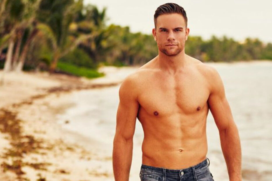 Der Bachelor 2020 posiert am Strand.